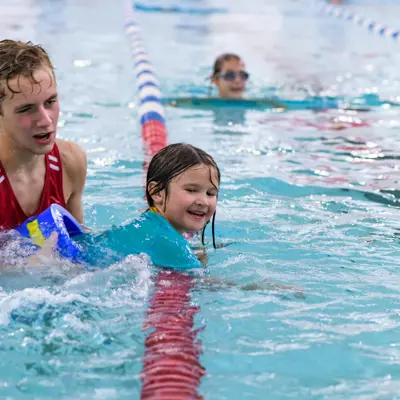 child swimming supervised by lifeguard