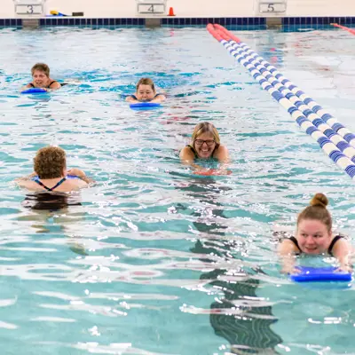 adults swimming in indoor pool