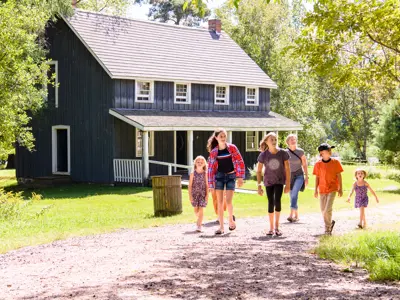 six people walking through outdoor trail at Muskoka Museum